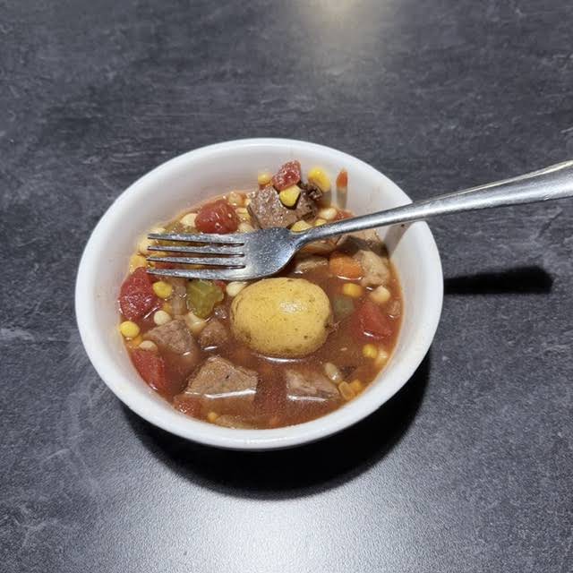 A bowl of soup with vegetables and beef at That's a Wrap