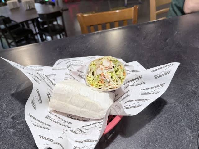 A freshly prepared wrap cut in half, served in a basket at That's a Wrap